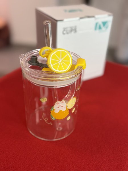 كوب زجاجي شفاف بغطاء وماصة.